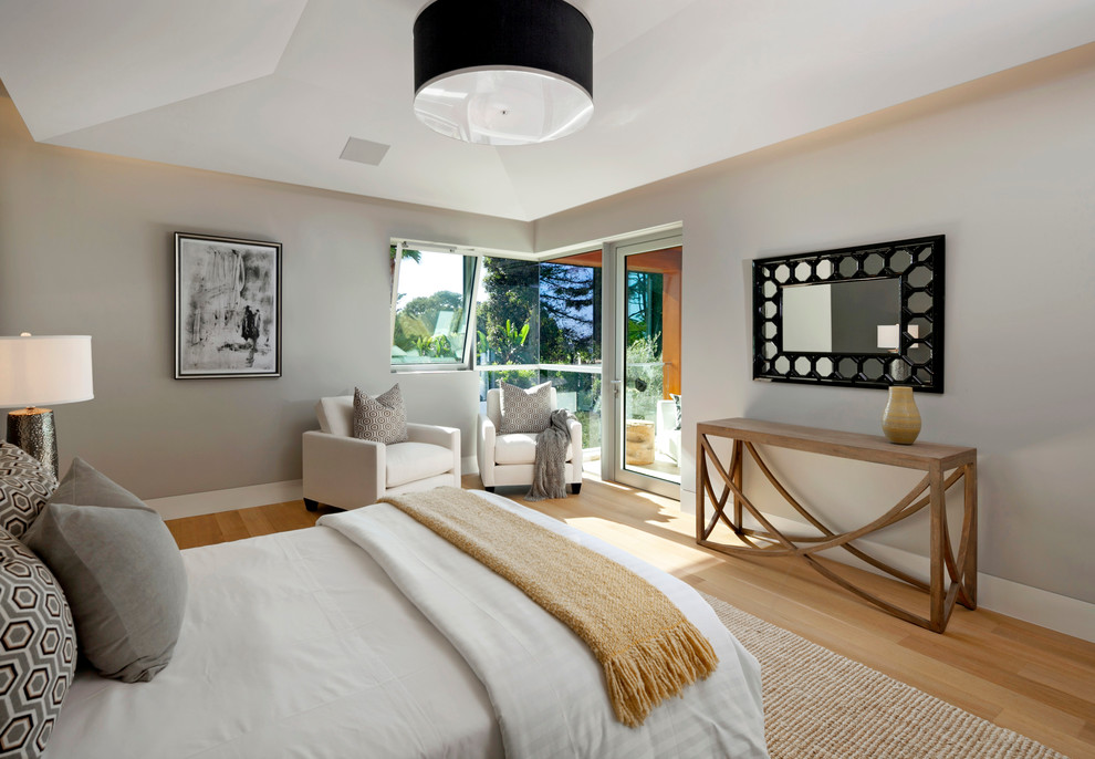 Foto de habitación de invitados moderna de tamaño medio sin chimenea con paredes beige y suelo de madera clara