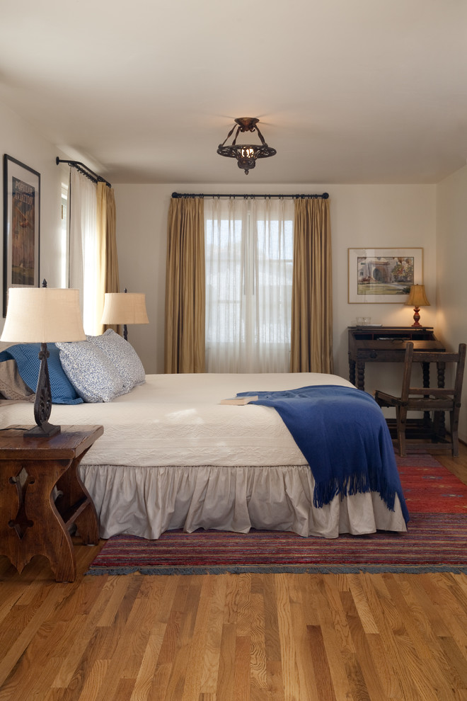 Mediterranes Schlafzimmer mit weißer Wandfarbe und braunem Holzboden in Santa Barbara