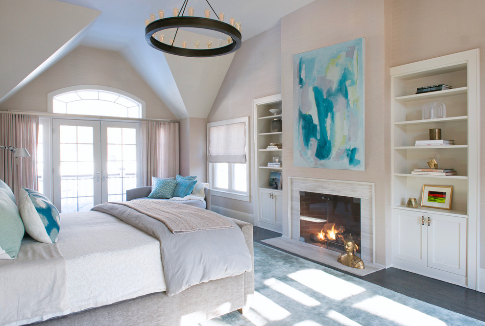 Inspiration pour une très grande chambre parentale minimaliste avec un mur gris, un manteau de cheminée en pierre, parquet foncé, une cheminée standard et un sol marron.
