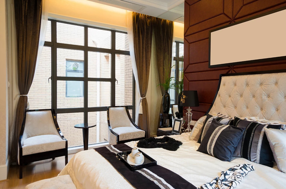 Diseño de dormitorio tipo loft bohemio grande sin chimenea con paredes beige, suelo de madera clara y suelo beige