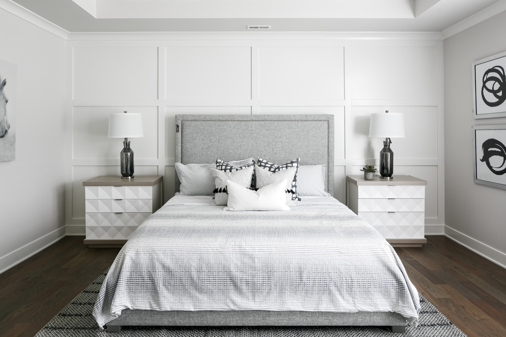 Пример оригинального дизайна: хозяйская, серо-белая спальня в стиле неоклассика (современная классика) с белыми стенами и темным паркетным полом без камина