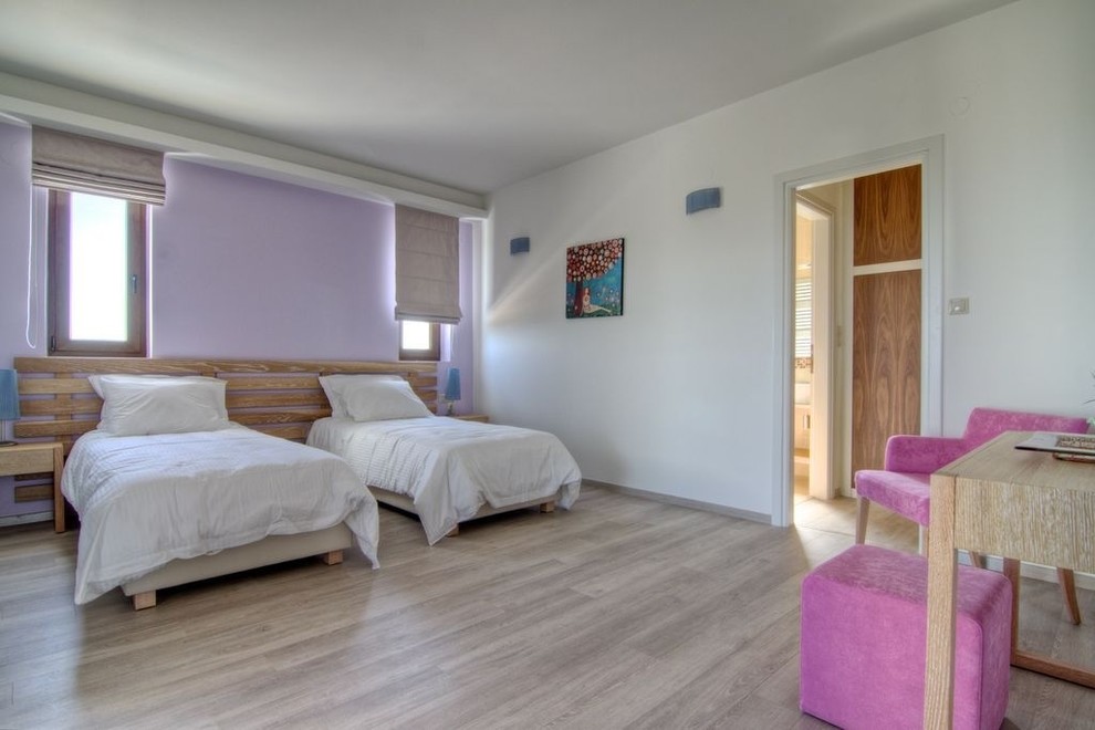 Inspiration for a contemporary guest bedroom in Other with purple walls and light hardwood flooring.