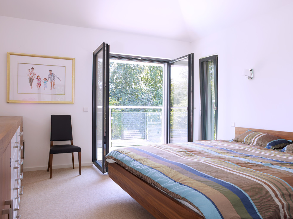 Photo of a contemporary bedroom in Cambridgeshire with white walls, carpet and brown floors.