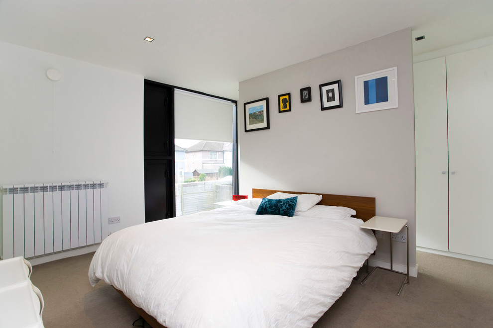 Immagine di una camera da letto moderna con pareti bianche
