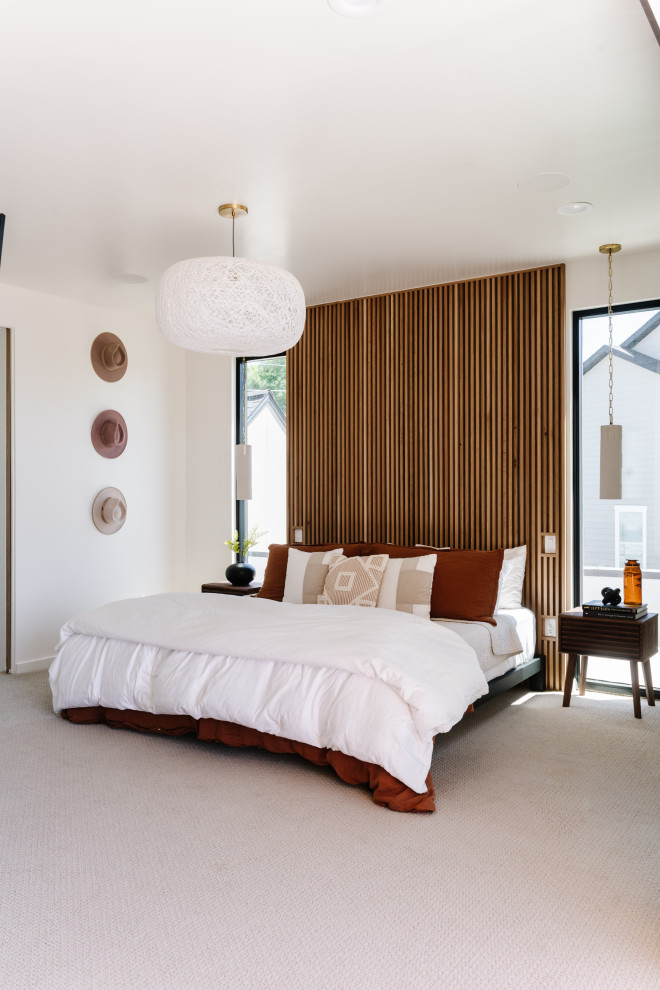 На фото: хозяйская спальня в современном стиле с белыми стенами, ковровым покрытием и деревянными стенами с