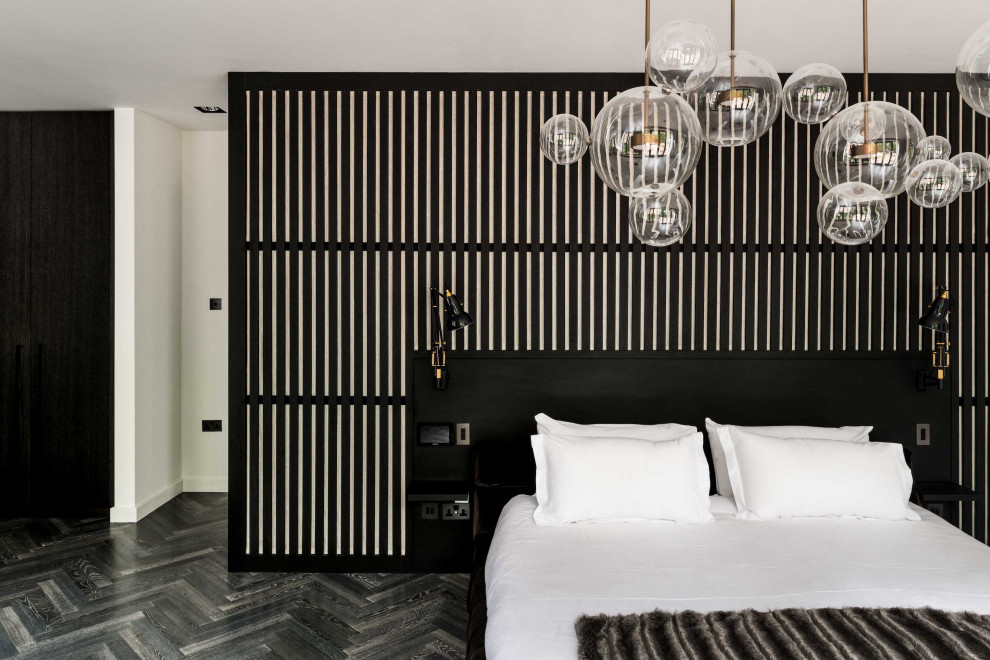Immagine di una grande camera matrimoniale contemporanea con pareti nere, parquet scuro e pavimento grigio