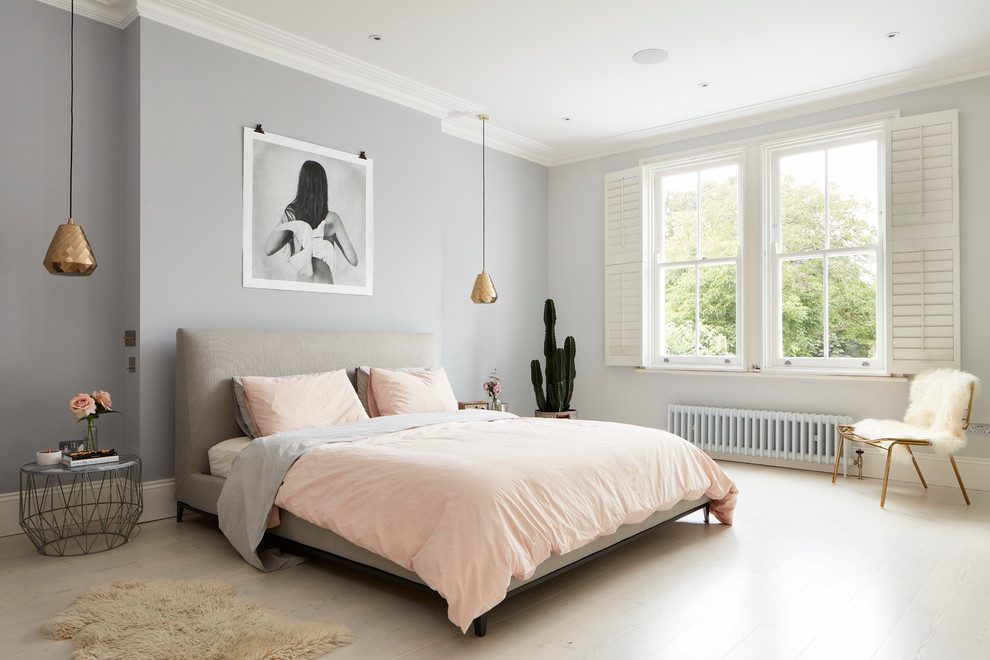 Contemporary grey and pink bedroom in London with grey walls and light hardwood flooring.