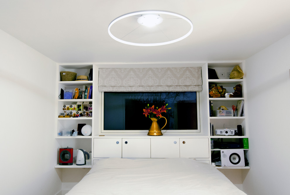 Modelo de dormitorio principal contemporáneo de tamaño medio con paredes blancas, suelo de madera en tonos medios y suelo marrón
