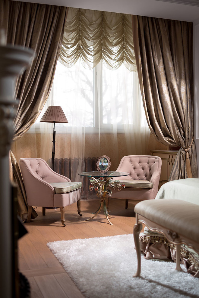 Immagine di una camera da letto classica di medie dimensioni con pareti beige, pavimento in legno massello medio e camino classico