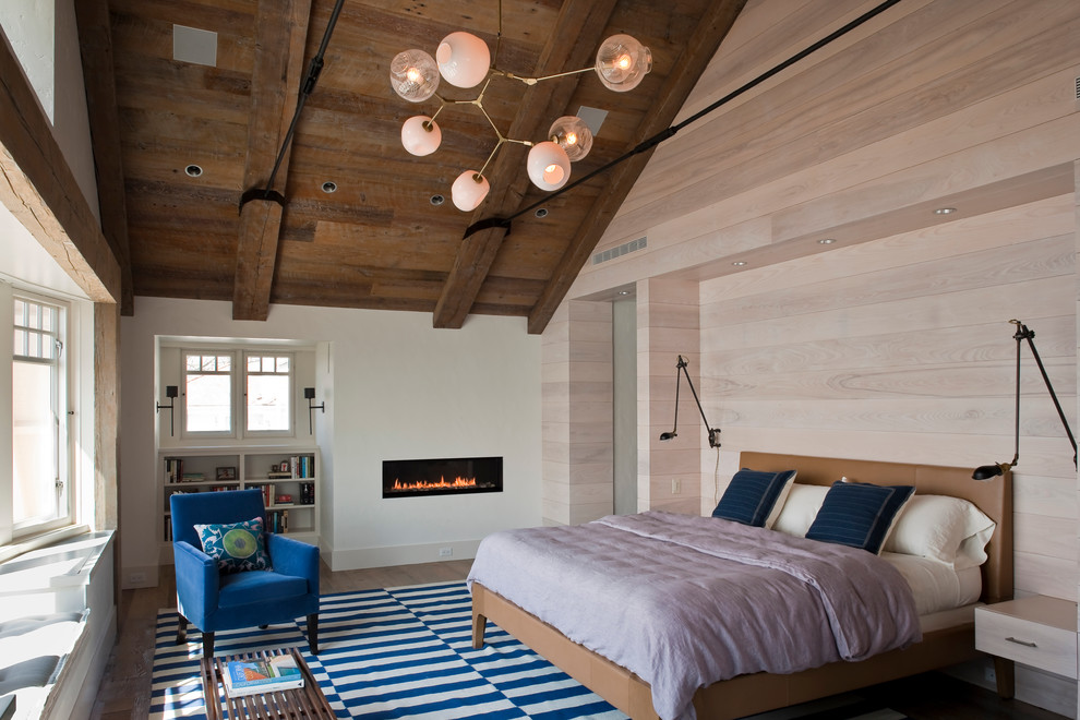 Photo of a coastal bedroom in New York with white walls, dark hardwood flooring and a ribbon fireplace.