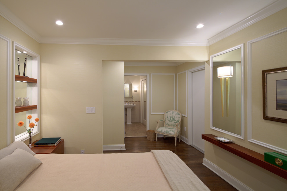 Idée de décoration pour une chambre parentale tradition de taille moyenne avec parquet foncé et un mur beige.