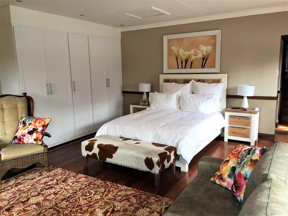 Стильный дизайн: большая хозяйская спальня в стиле фьюжн с белыми стенами, полом из ламината и коричневым полом - последний тренд
