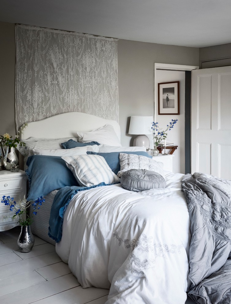 Foto de habitación de invitados romántica con paredes grises y suelo de madera clara