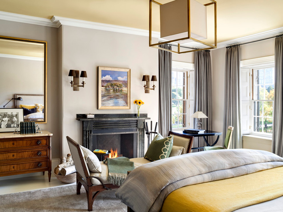 Foto de habitación de invitados clásica renovada extra grande con paredes beige, suelo de madera en tonos medios, todas las chimeneas y marco de chimenea de piedra