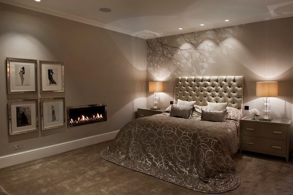 Large trendy master carpeted bedroom photo in Surrey with beige walls, a ribbon fireplace and a plaster fireplace