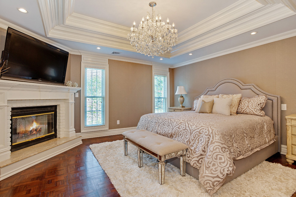 Example of a mid-sized classic master dark wood floor bedroom design in New York with beige walls, a corner fireplace and a brick fireplace