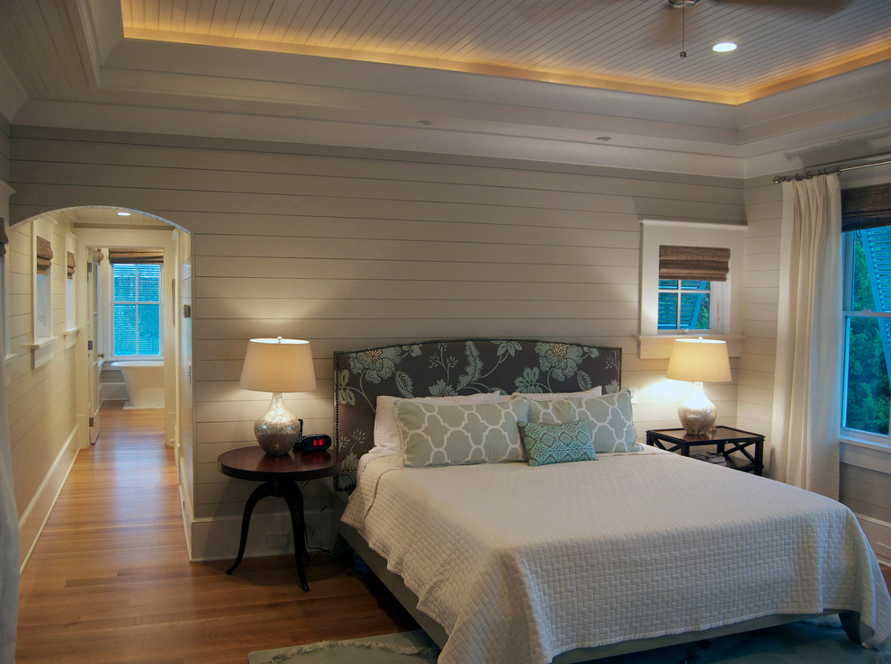 Large elegant master medium tone wood floor bedroom photo in Charleston with white walls