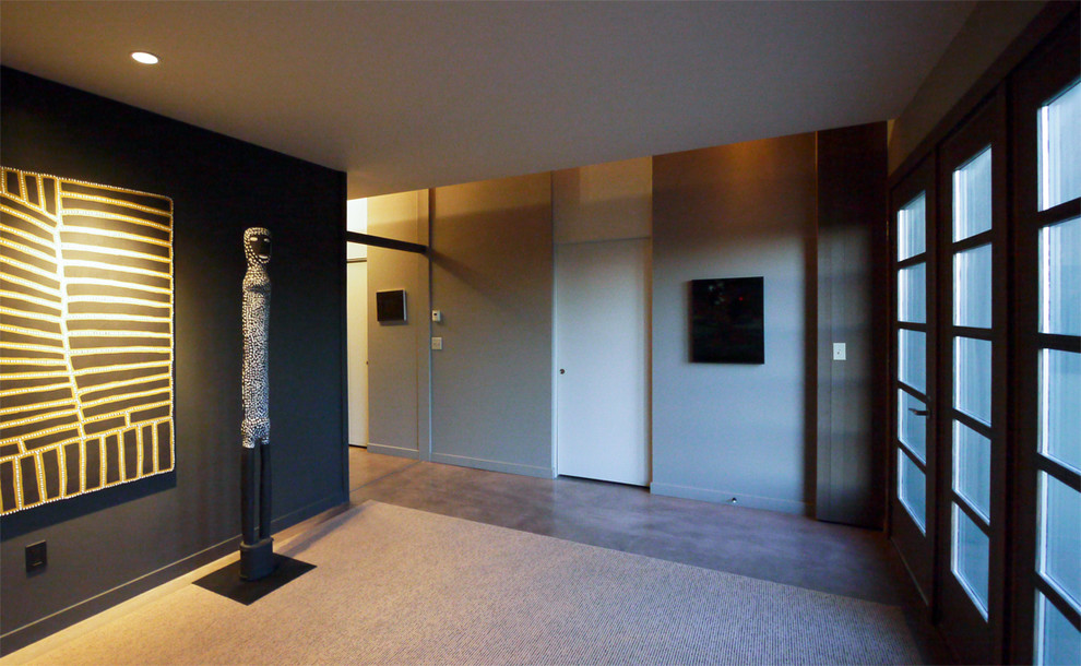 Exemple d'une chambre d'amis tendance de taille moyenne avec un mur beige et sol en béton ciré.