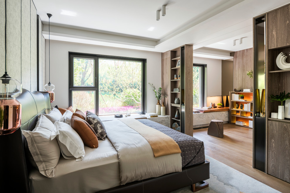 Photo of a contemporary master and grey and brown bedroom in London with white walls, medium hardwood flooring and brown floors.