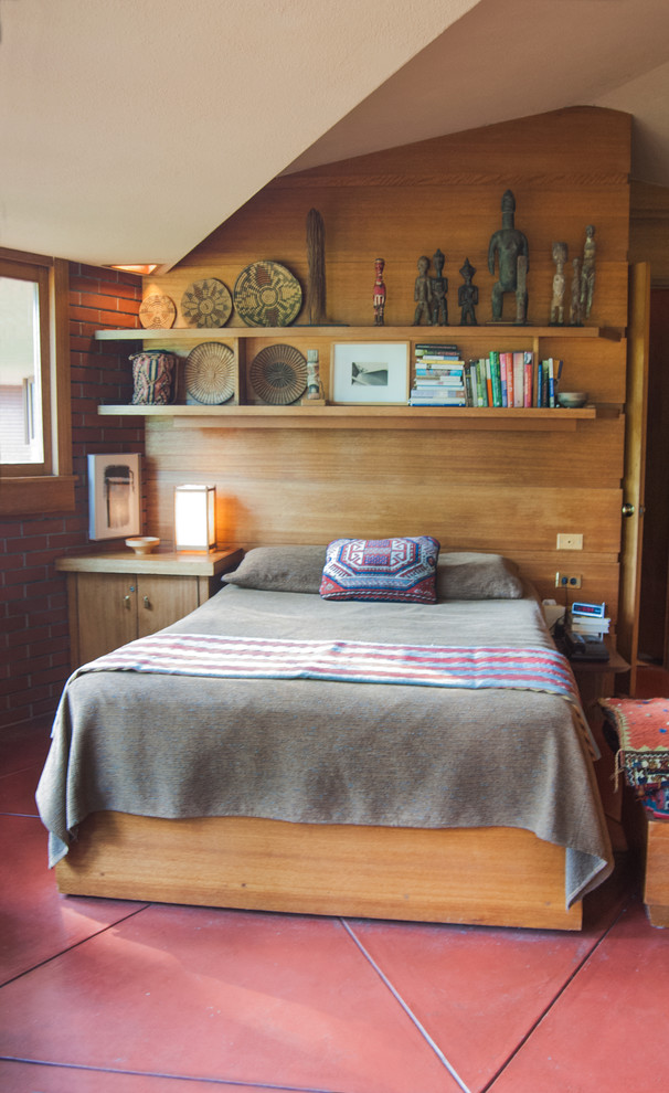 Immagine di una piccola camera da letto minimalista con pavimento rosso