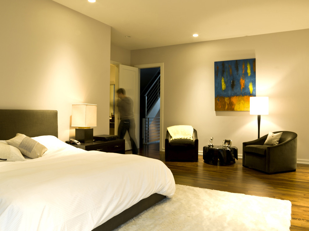 Modelo de dormitorio minimalista con paredes beige y suelo de madera en tonos medios