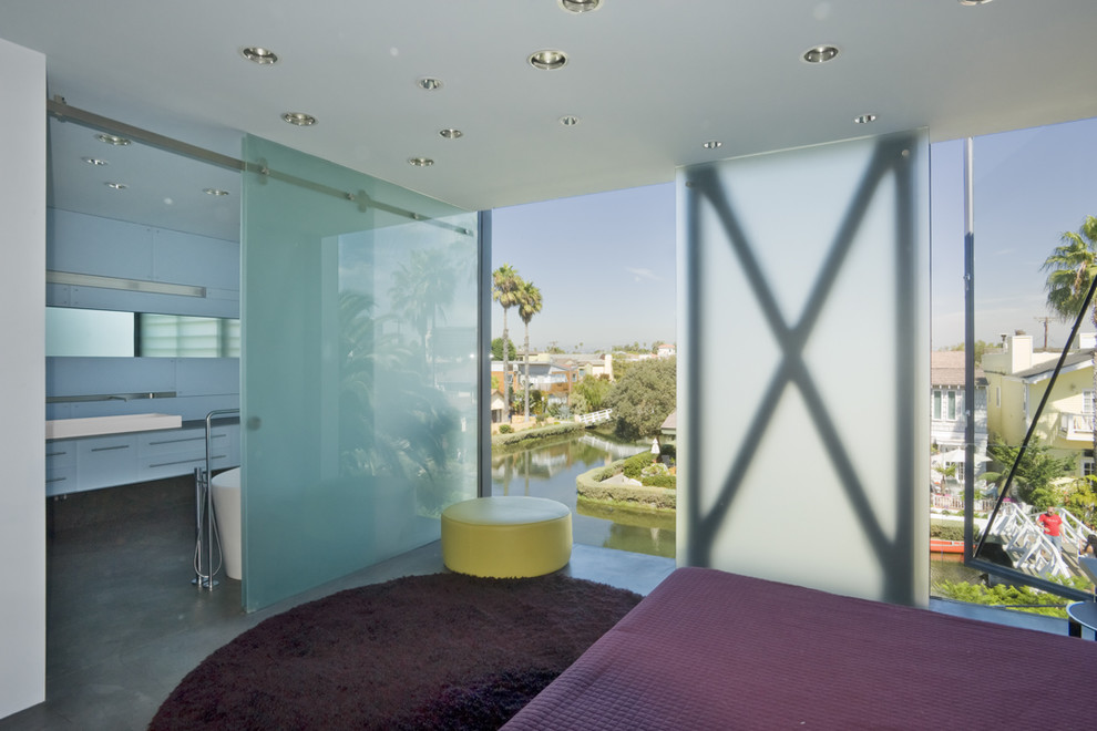 Contemporary bedroom in Los Angeles with concrete flooring.