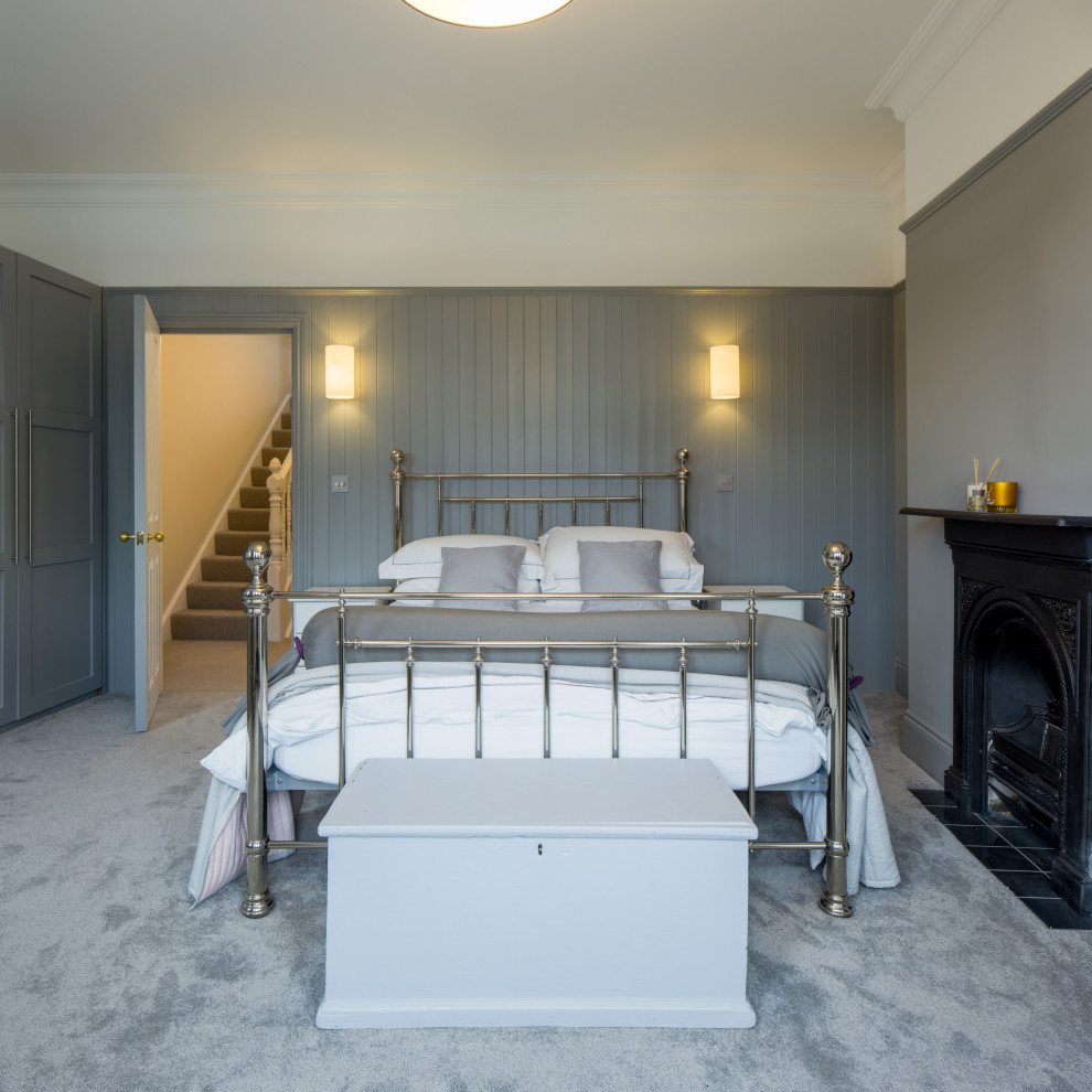 На фото: большая гостевая спальня (комната для гостей) в современном стиле с серыми стенами, ковровым покрытием, стандартным камином, фасадом камина из металла, серым полом, кессонным потолком и стенами из вагонки