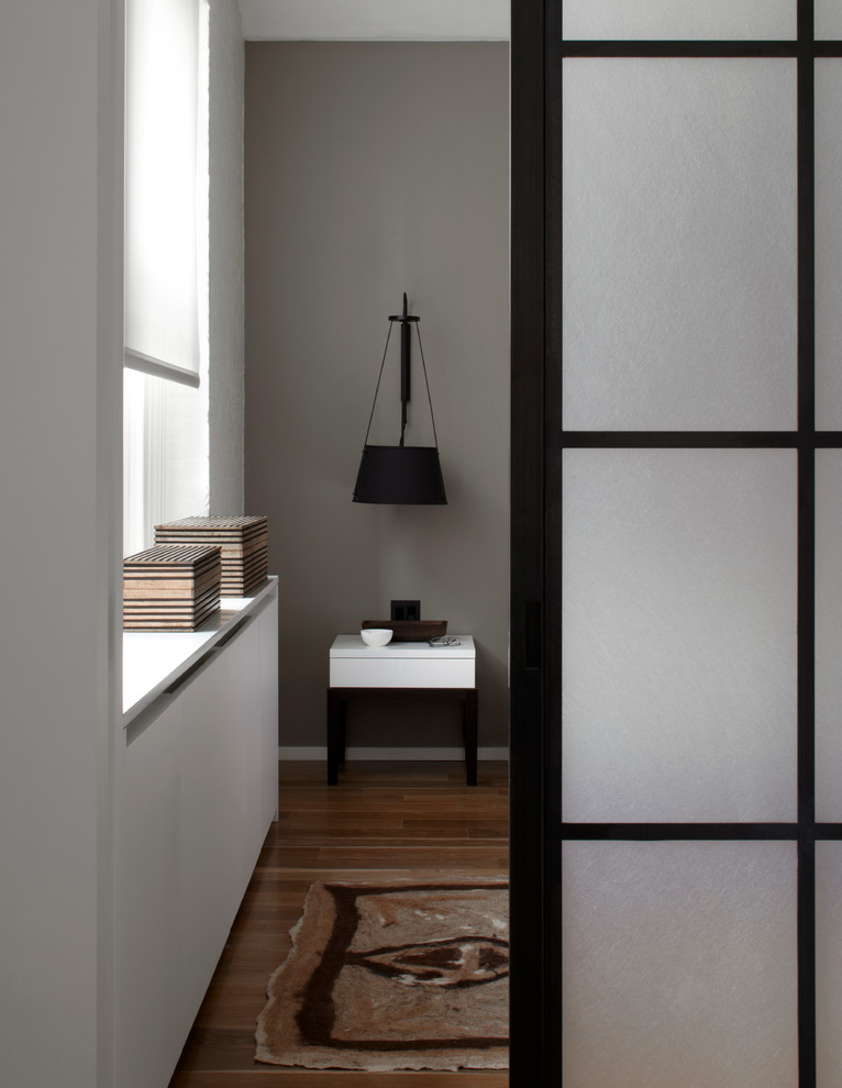 Contemporary bedroom in New York with grey walls and medium hardwood flooring.