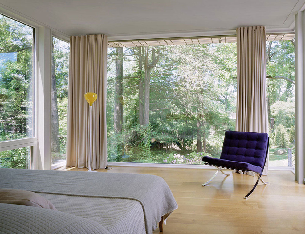 На фото: большая хозяйская спальня в стиле модернизм с белыми стенами и светлым паркетным полом без камина с