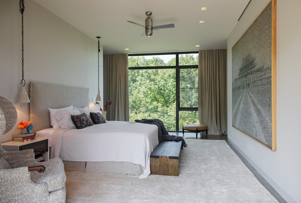 На фото: большая спальня в стиле модернизм с белыми стенами, бетонным полом и серым полом с