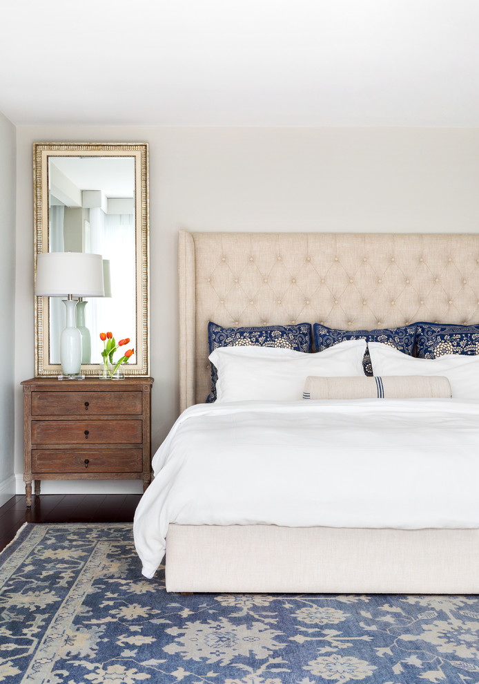 Photo of a coastal bedroom in New York with beige walls and dark hardwood flooring.
