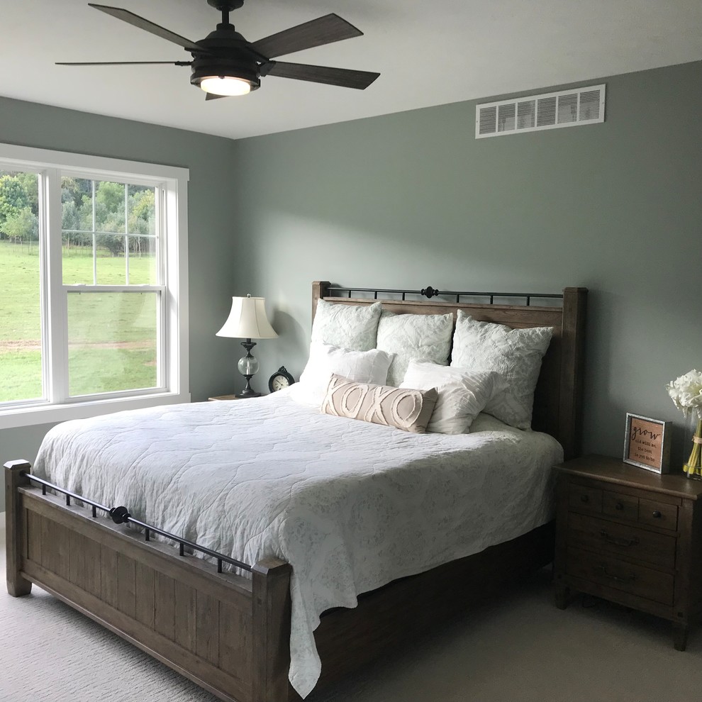 Modelo de dormitorio principal de estilo de casa de campo de tamaño medio con paredes verdes, moqueta y suelo beige