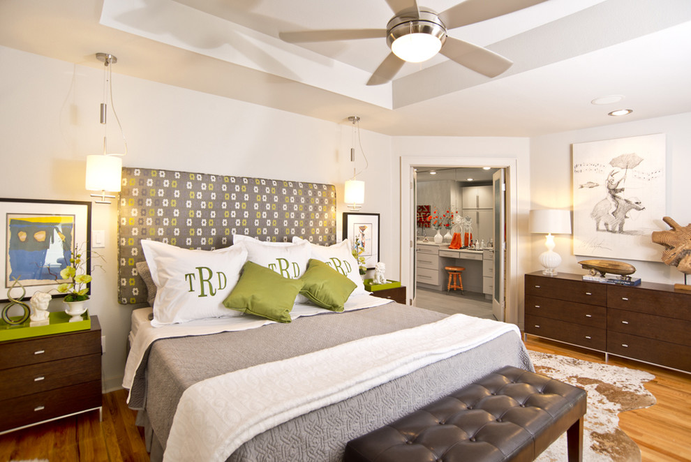 Imagen de dormitorio principal moderno de tamaño medio con paredes blancas y suelo de madera en tonos medios