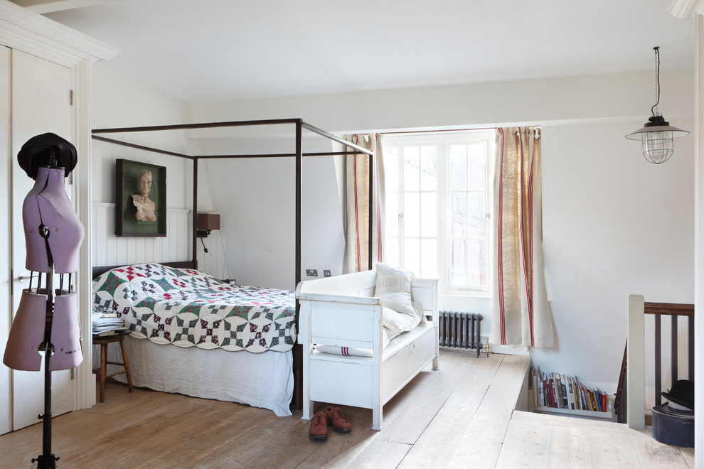 ロンドンにある北欧スタイルのおしゃれなロフト寝室 (白い壁、淡色無垢フローリング、勾配天井) のレイアウト