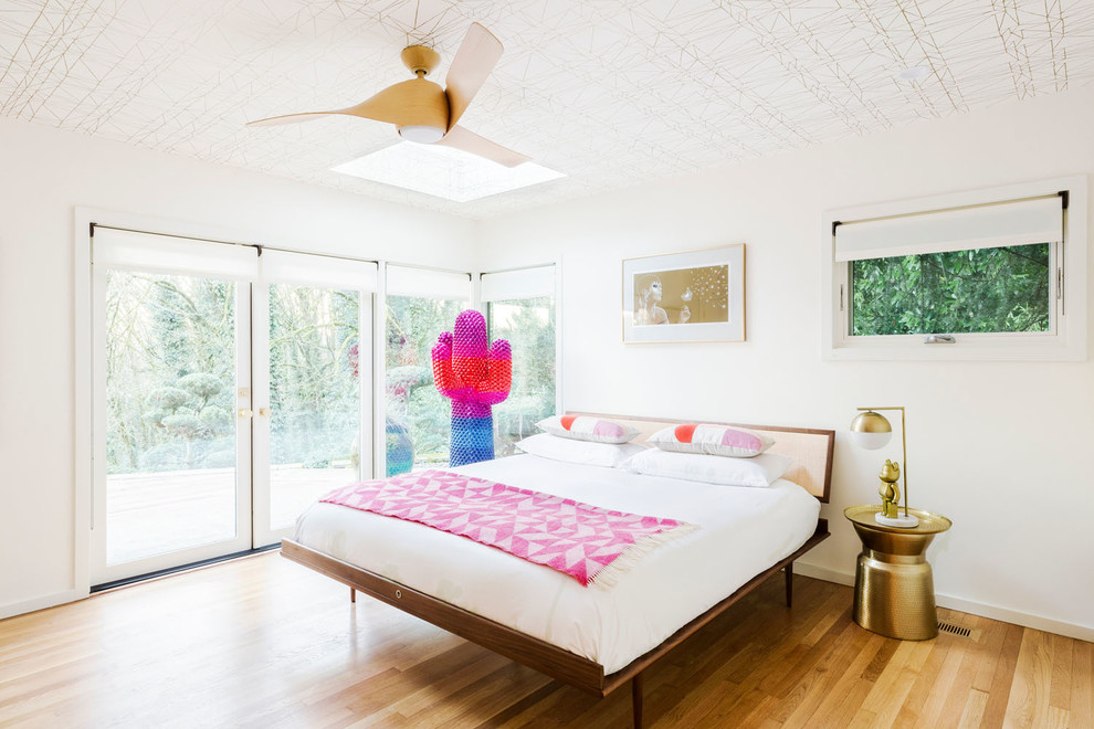 Imagen de habitación de invitados retro de tamaño medio con paredes blancas, suelo de madera clara y suelo beige