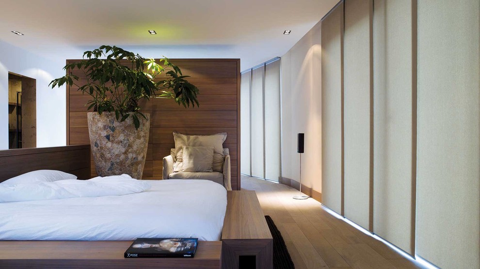 Großes Asiatisches Hauptschlafzimmer ohne Kamin mit weißer Wandfarbe und hellem Holzboden in Toronto