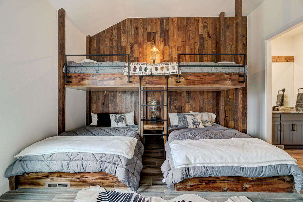 Idées déco pour une chambre d'amis montagne avec un mur blanc, un sol en bois brun et un sol marron.