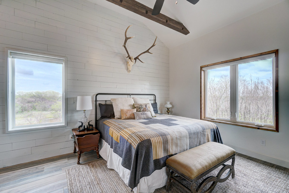 Ispirazione per una camera da letto rustica con pareti bianche, pavimento in legno massello medio e pavimento marrone