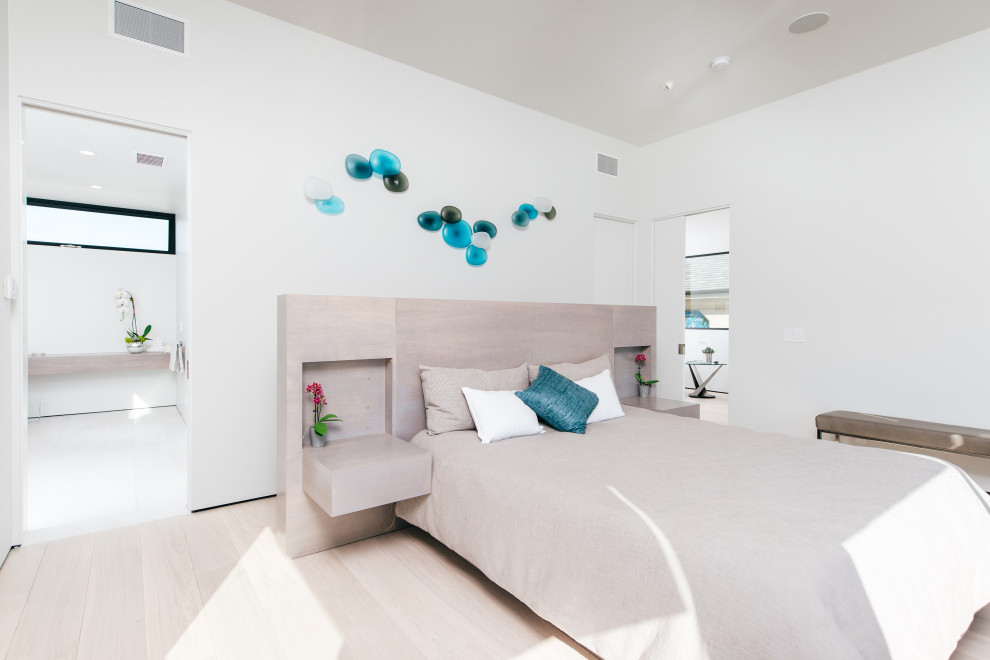 Inspiration for a large coastal master and grey and teal bedroom in Orange County with white walls, light hardwood flooring and beige floors.