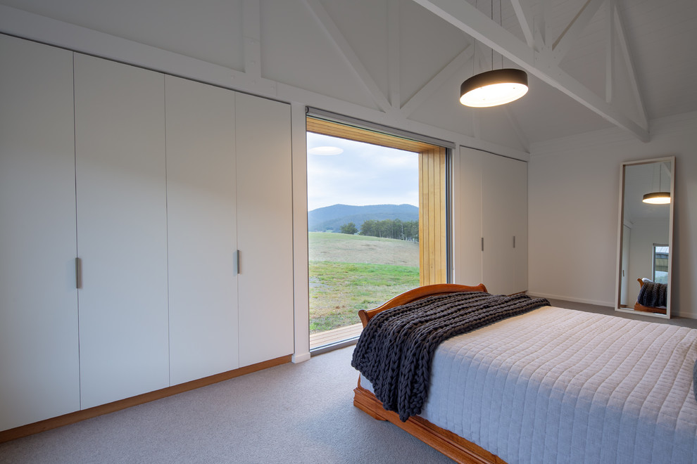 Mittelgroßes Country Hauptschlafzimmer mit weißer Wandfarbe, Teppichboden und grauem Boden in Hobart