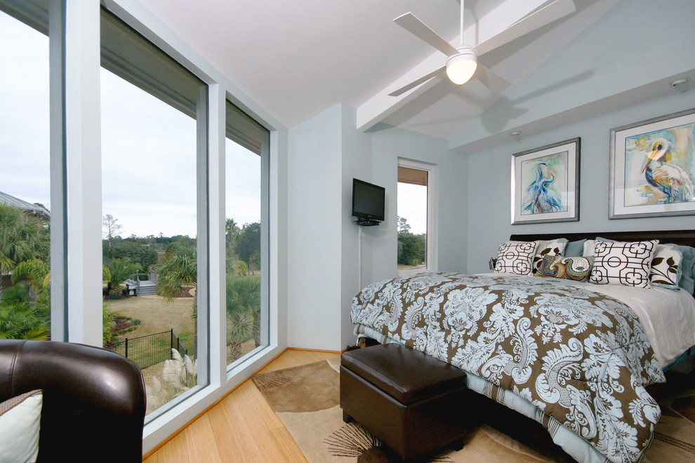 Foto de habitación de invitados costera de tamaño medio con suelo de bambú y paredes azules