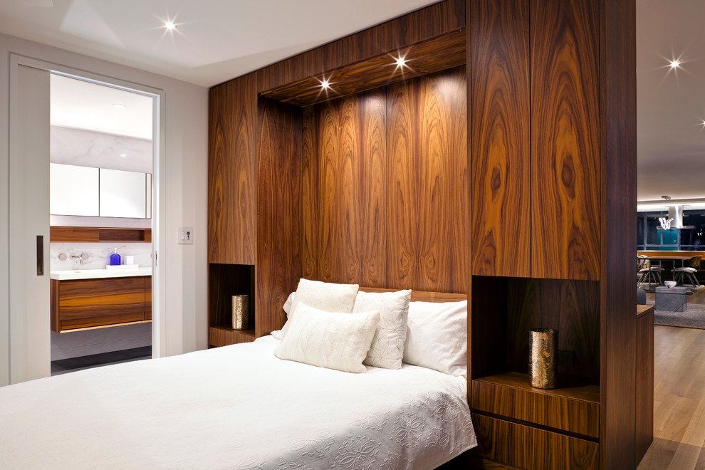 Modelo de habitación de invitados moderna de tamaño medio sin chimenea con paredes blancas y suelo de madera clara