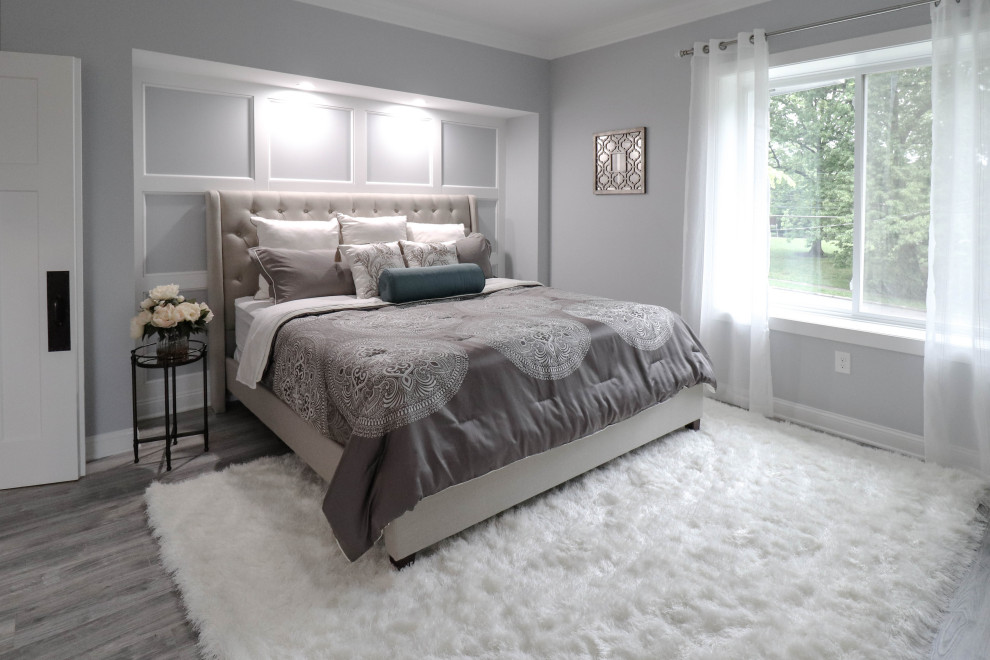 Design ideas for a large traditional master bedroom in Cincinnati with grey walls, laminate floors, a standard fireplace, a tiled fireplace surround and grey floors.