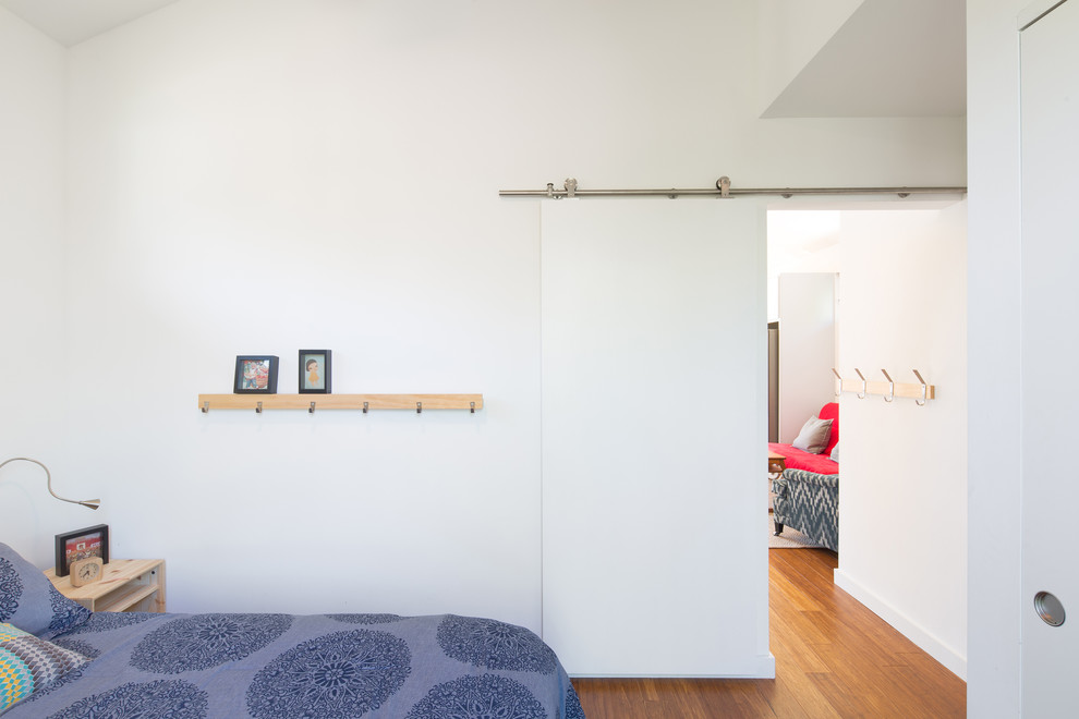 Cette photo montre une petite chambre parentale chic avec un mur blanc, un sol en bois brun et aucune cheminée.