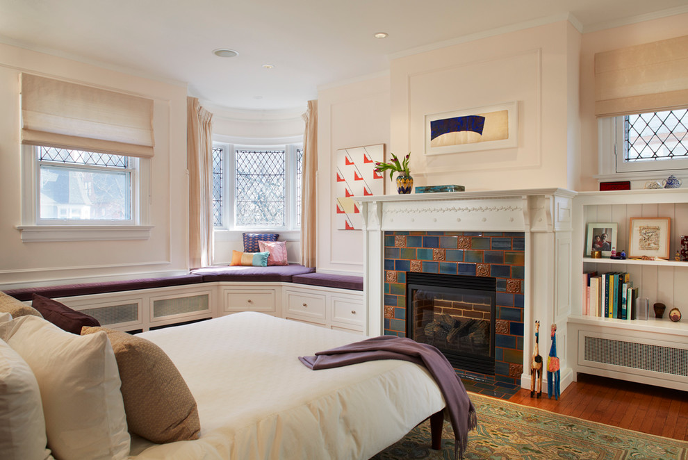 Idées déco pour une chambre victorienne avec un mur beige, un sol en bois brun, une cheminée standard et un manteau de cheminée en carrelage.