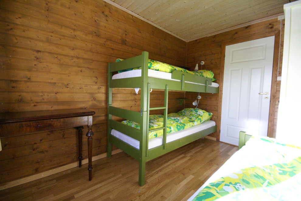 Foto de habitación de invitados tradicional pequeña sin chimenea con paredes marrones y suelo de madera en tonos medios