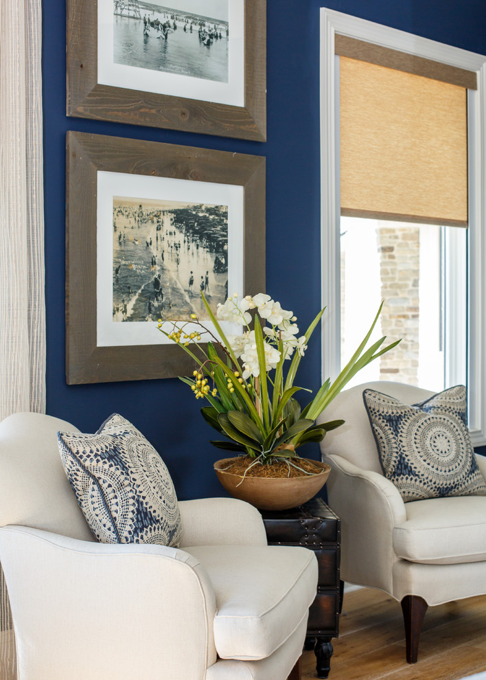 Design ideas for a coastal guest bedroom in Jacksonville with blue walls and medium hardwood flooring.