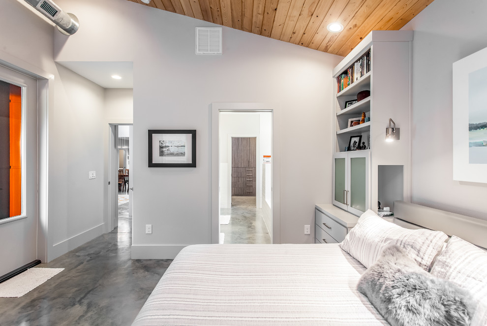 Exemple d'une chambre parentale tendance de taille moyenne avec sol en béton ciré et un sol gris.