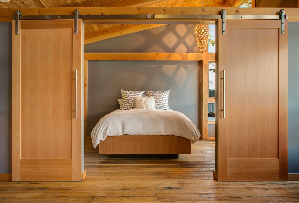 Idee per una camera degli ospiti design con pareti grigie e pavimento in legno massello medio