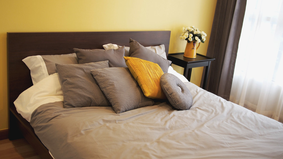 ニューヨークにある中くらいなトランジショナルスタイルのおしゃれな主寝室 (淡色無垢フローリング、暖炉なし、黄色い壁)